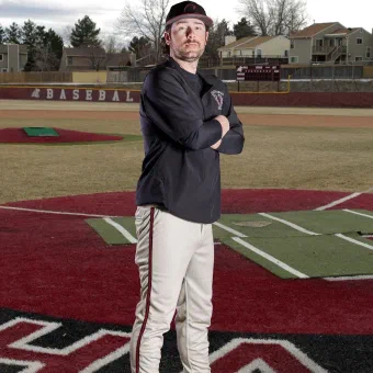 Baseball player posing confidently on the field near home plate.